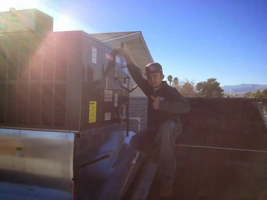HVAC technician performing HVAC Inspection on a rooftop unit in Shelbyville